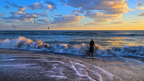 A man fishing in the ocean waves