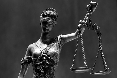 A sculpture of blind justice holding a balance